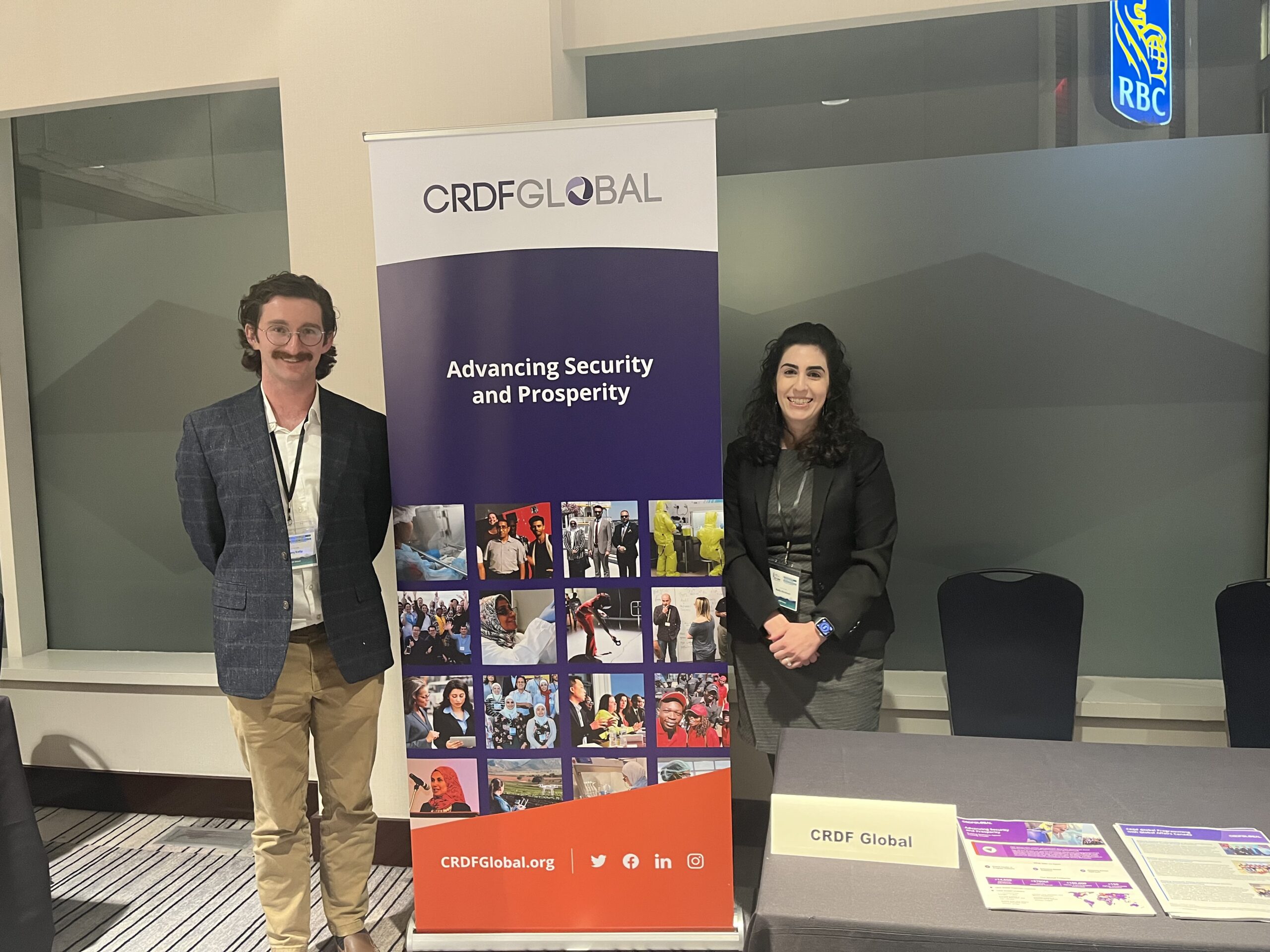 2 people in front of a banner